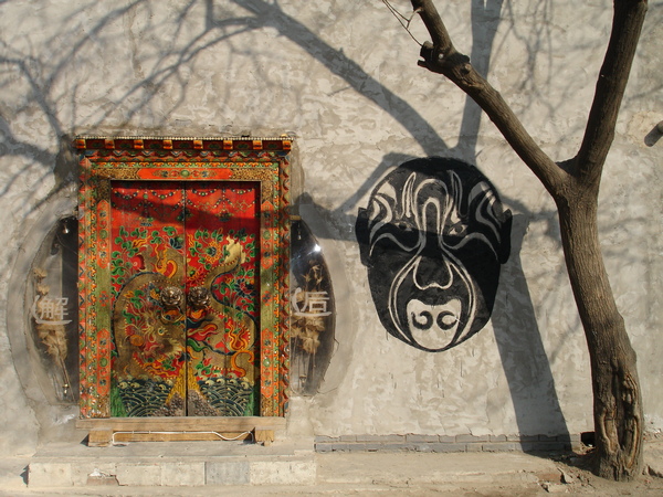 Meuble incrusté dans un mur et masque peint sur le mur