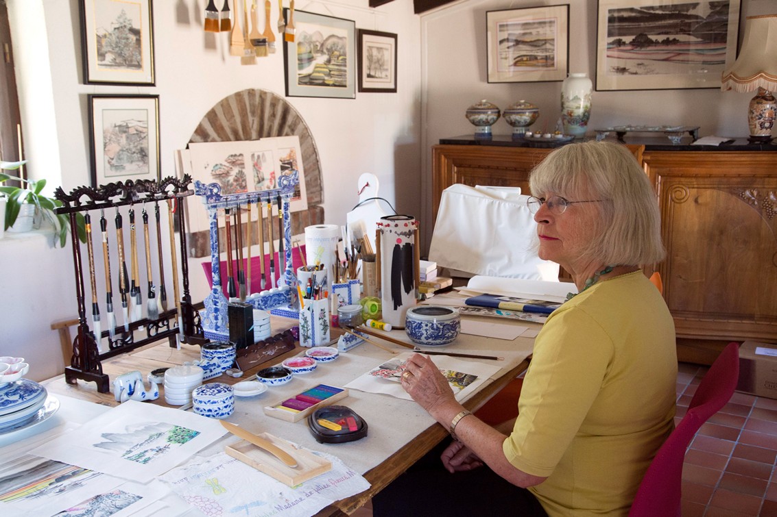 Artiste assis a son bureau, vue de profil